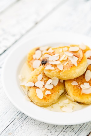 Delicious homemade cheese pancakes with raisins on rustic wooden tableの写真素材