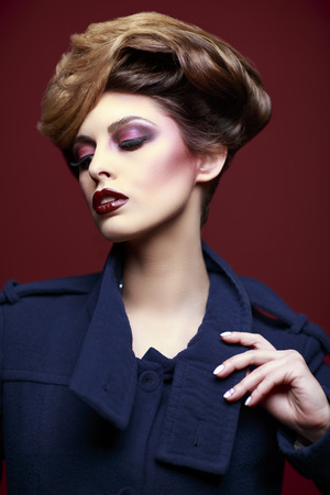 Beauty styled closeup portrait of a young woman on red backgroundの写真素材