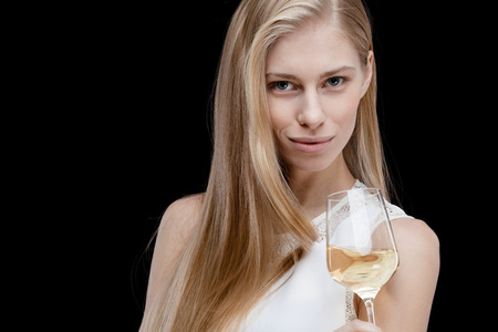 young blond woman holding glass of white wineの写真素材