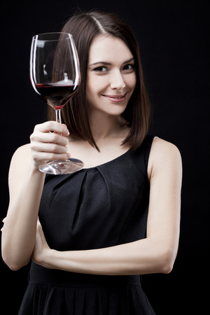young beautiful woman holding glass of red wineの写真素材