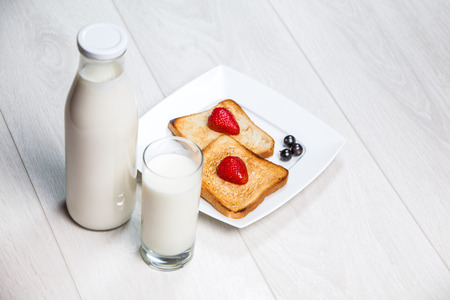 milk bottle and glass with toasts on wooden backgroundの写真素材
