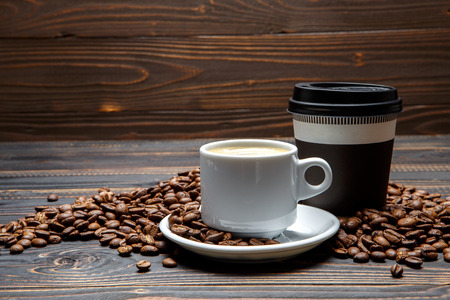roasted coffee beans and cup on wooden background