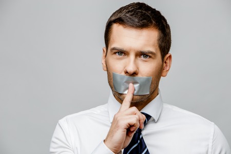 businessman with tape sealed mouthの写真素材