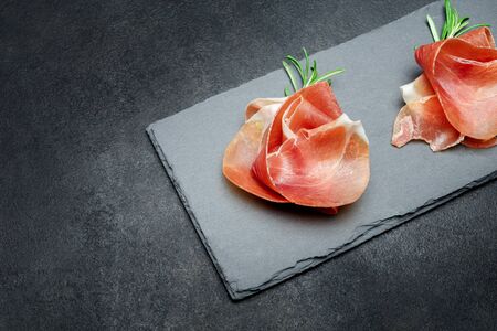 Italian prosciutto crudo or spanish jamon. Raw ham on stone cutting boardの写真素材