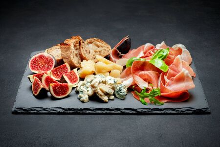Italian prosciutto crudo or spanish jamon, cheese, figs and breadの写真素材