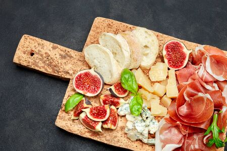 Italian prosciutto crudo or spanish jamon, cheese, figs and breadの写真素材