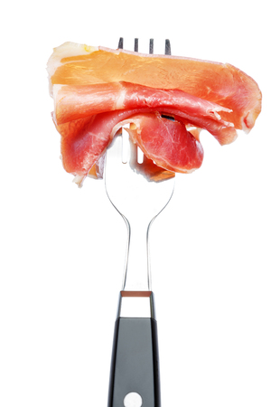Italian prosciutto crudo or spanish jamon on forkの写真素材