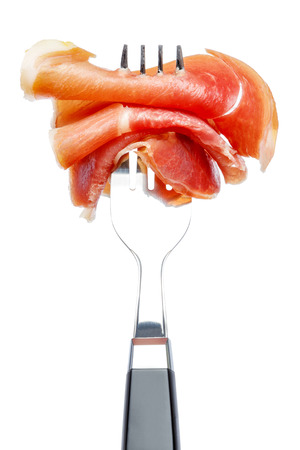 Italian prosciutto crudo or spanish jamon on forkの写真素材