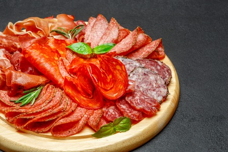 Cold meat plate with salami and chorizo sausage on wooden board