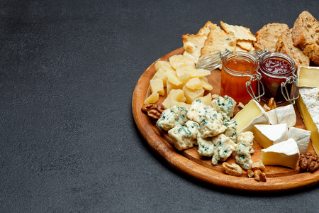 Brie cheese on a wooden Board with bread and sweet jamの写真素材