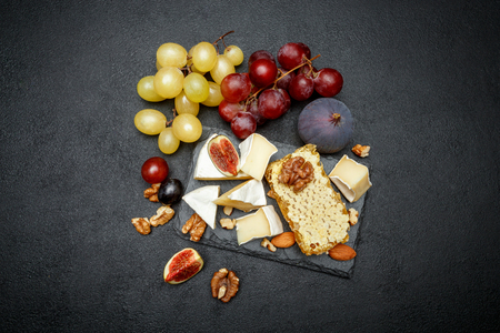 Camembert cheese with honey, figs, walnuts on stone boardの写真素材