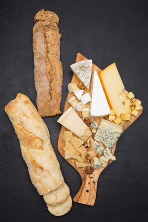 various types of cheese and bread on wooden boardの写真素材