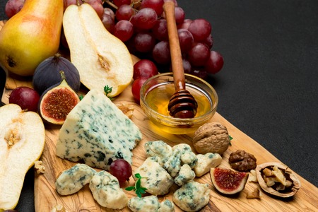 Slice of French Roquefort cheese and pear on wooden boardの写真素材