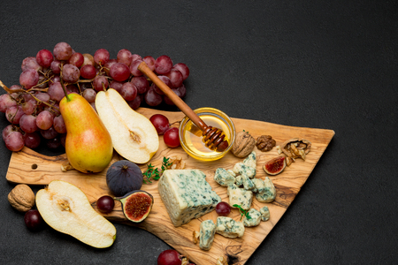 Slice of French Roquefort cheese and pear on wooden boardの写真素材