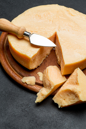 Whole round Head and pieces of parmesan or parmigianoの写真素材