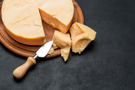 Whole round Head and pieces of parmesan or parmigianoの写真素材