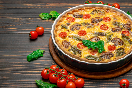 Baked homemade quiche pie in ceramic baking form on concrete backgroundの写真素材