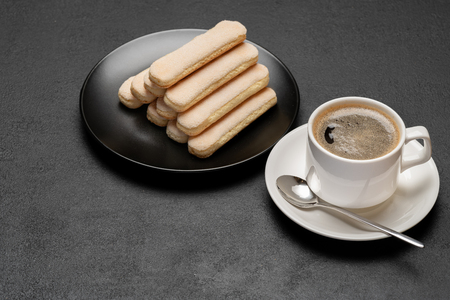 Italian Savoiardi ladyfingers Biscuits and cup of coffee on concrete backgoundの写真素材