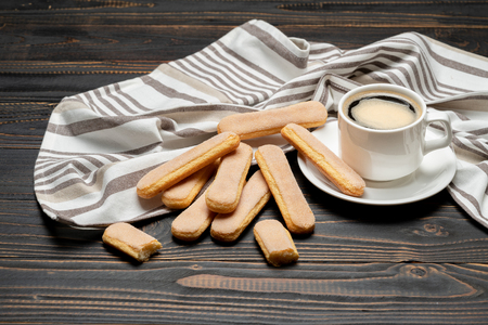 Italian Savoiardi ladyfingers Biscuits and cup of coffee on wooden backgoundの写真素材