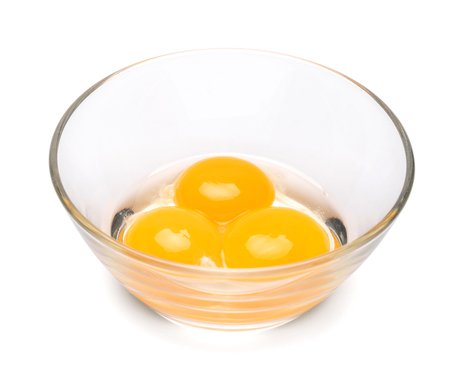 three egg yolk in a glass bowl isolated on white background with clipping pathの写真素材