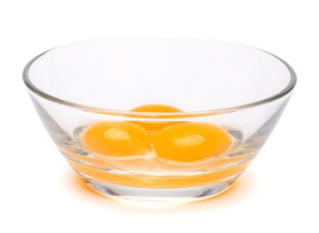 three egg yolk in a glass bowl isolated on white background with clipping pathの写真素材
