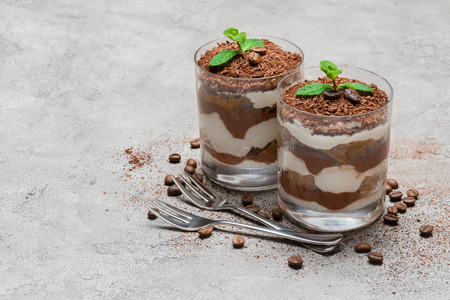 two portions Classic tiramisu dessert in a glass on concrete backgroundの写真素材