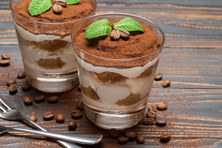 two portions Classic tiramisu dessert in a glass on wooden backgroundの写真素材