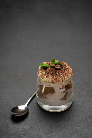 portion of Classic tiramisu dessert in a glass on concrete backgroundの写真素材