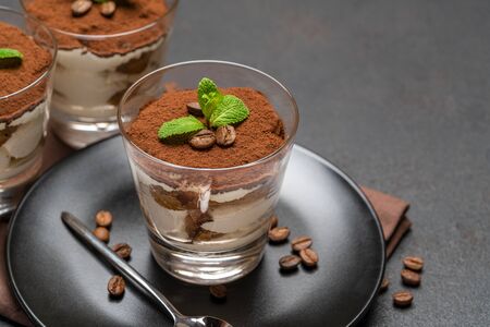 Classic tiramisu dessert in a glass on dark concrete backgroundの写真素材