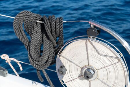black mooring lines hanging on the reeling on a sailing yacht