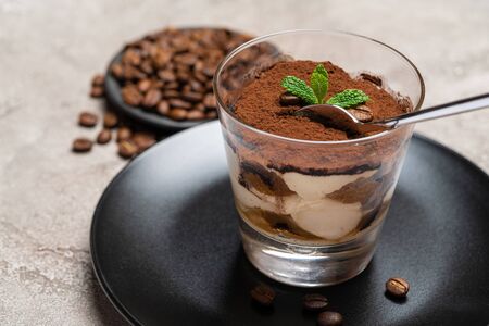 Portion of Classic tiramisu dessert in a glass cup on concrete backgroundの写真素材
