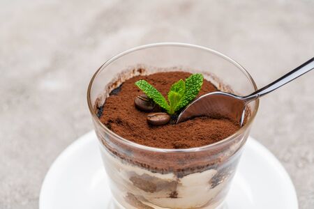 Portion of Classic tiramisu dessert in a glass cup on concrete backgroundの写真素材