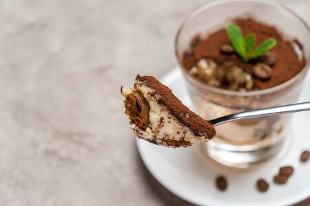 Portion of Classic tiramisu dessert in a glass cup on concrete backgroundの写真素材