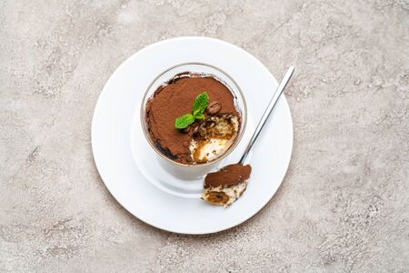 Portion of Classic tiramisu dessert in a glass cup on concrete backgroundの写真素材