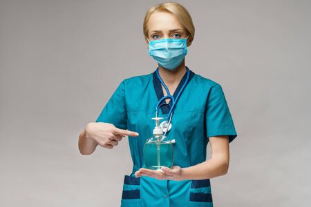 medical doctor nurse wearing protective mask - holding sanitizing spray or gel or liquid soapの写真素材