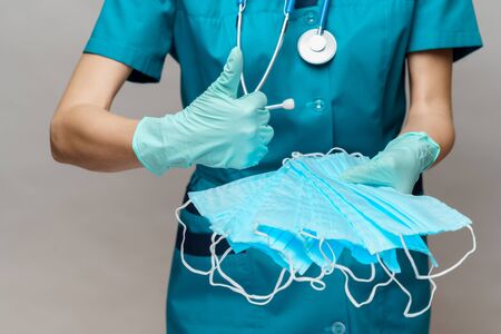 medical doctor nurse woman with stethoscope over light grey background - showing protective maskの写真素材