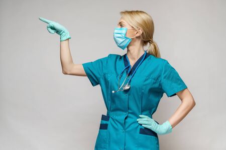 medical doctor nurse woman wearing protective mask and latex gloves - showing at virtual listの写真素材