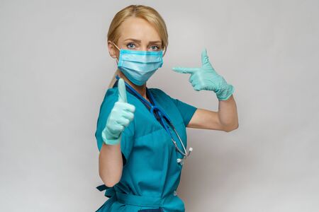 medical doctor nurse woman wearing protective mask and latex gloves - showing big thumb upの写真素材