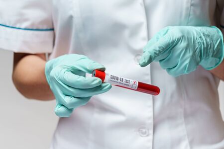 medical doctor nurse woman wearing protective mask and gloves - holding virus blood test