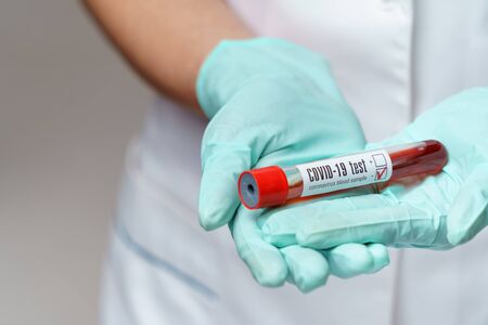 medical doctor nurse woman wearing protective mask and gloves - holding virus blood testの写真素材