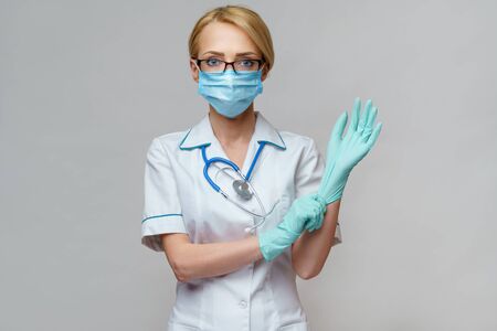 medical doctor nurse woman with stethoscope wearing protective mask and rubber latex glovesの写真素材