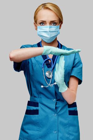 medical doctor nurse woman with stethoscope wearing protective mask and rubber or latex glovesの写真素材