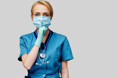 medical doctor nurse woman with stethoscope wearing protective mask and rubber or latex glovesの写真素材