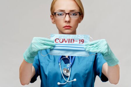 medical doctor nurse woman with stethoscope wearing protective mask and rubber or latex glovesの写真素材