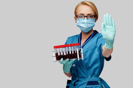 medical doctor nurse woman wearing protective mask and gloves - holding rack with virus blood tests