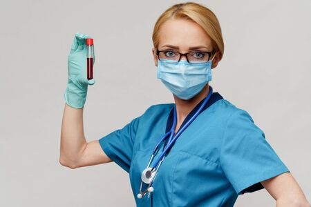 medical doctor nurse woman wearing protective mask and gloves - holding virus blood test tubeの写真素材