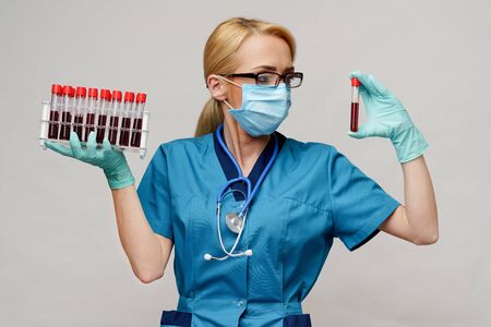 medical doctor nurse woman wearing protective mask and gloves - holding rack with virus blood testsの写真素材