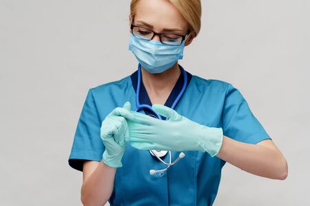 medical doctor nurse woman with stethoscope wearing protective mask and rubber or latex glovesの写真素材