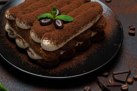 Classic tiramisu dessert on ceramic plate on concrete backgroundの写真素材