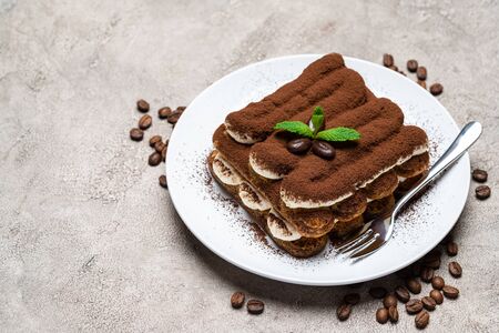Classic tiramisu dessert on ceramic plate on concrete backgroundの写真素材